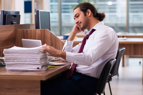 Jeune employé masculin et trop de travail au bureau — Photo