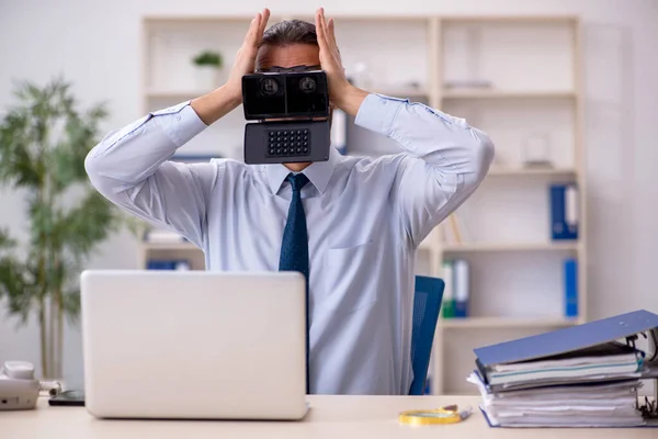 Jovem funcionário masculino vestindo óculos virtuais no local de trabalho — Fotografia de Stock