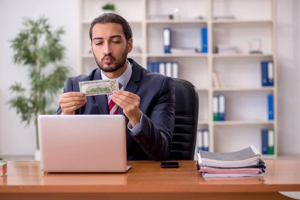 Ung manlig anställd som innehar sedlar på kontoret — Stockfoto