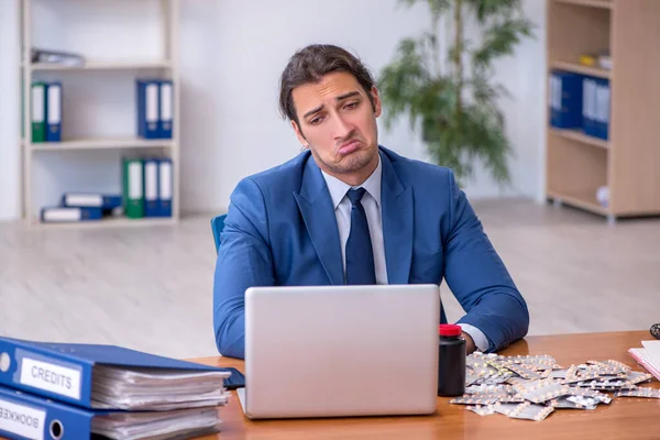 Young male sick employee suffering at workplace — Stock Photo, Image