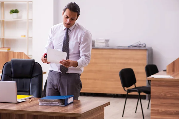 Jeune employé papier agrafage dans le bureau — Photo