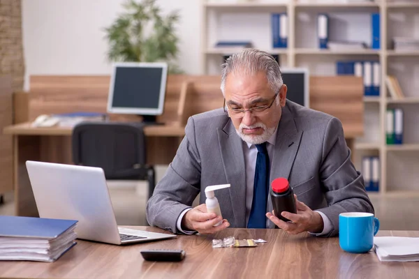 Coronavirus infected old businessman employee sitting in the off