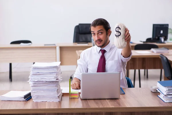 Ung manlig anställd som håller penningpåse på kontoret — Stockfoto