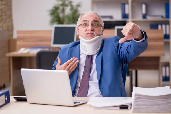 Old businessman employee after accident working in the office