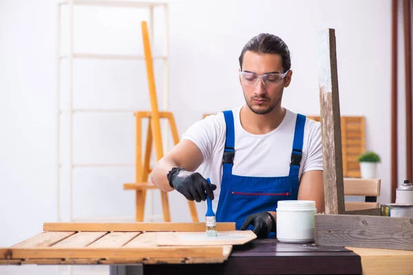 Jonge mannelijke aannemer werkzaam in werkplaats — Stockfoto