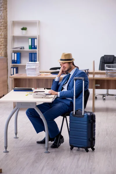 Ung manlig anställd förbereder sig för resa på kontoret — Stockfoto