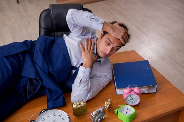 Jeune employé masculin dormant dans le bureau en gestion du temps co — Photo