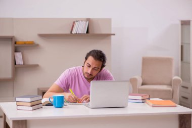 Evde sınava hazırlanan genç bir erkek öğrenci.