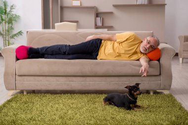 Evde köpeği olan yaşlı bir adam.