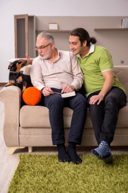 Evde köpekli iki adam.