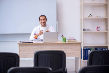 Genç erkek doktor sınıfta seminer veriyor.