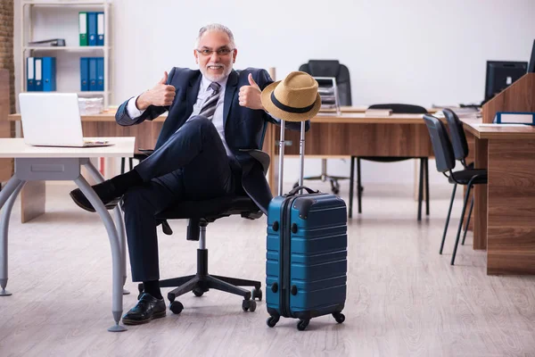 Oude mannelijke werknemer bereidt zich voor op reizen in het kantoor — Stockfoto