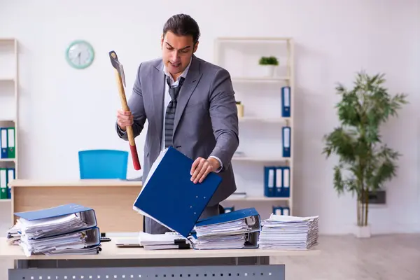 Junge Angestellte wütend über übermäßige Arbeit mit Beil — Stockfoto