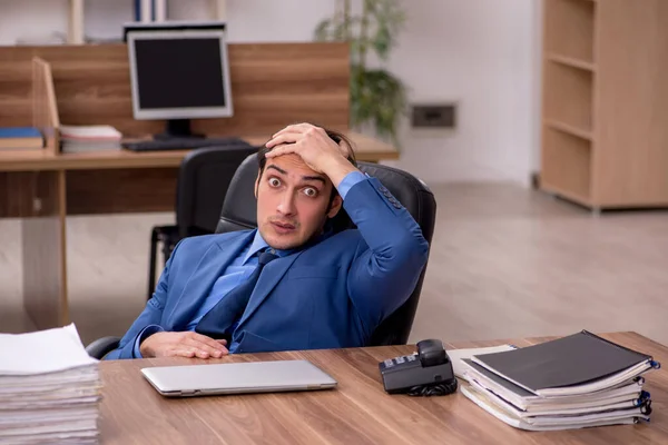 Junge männliche Mitarbeiter und viel Arbeit im Büro — Stockfoto