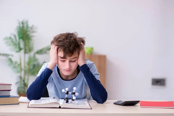 Schooljongen kijkt thuis naar moleculair model — Stockfoto