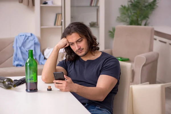 若い失業中の男は自宅でアルコールを飲む — ストック写真