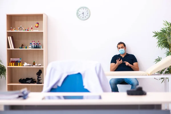 Jeune homme attendant un médecin pendant une pandémie à l'hôpital — Photo