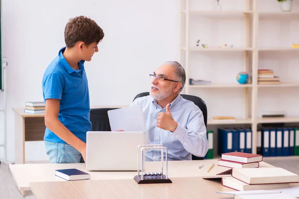 Oude mannelijke leraar en schooljongen in de klas — Stockfoto