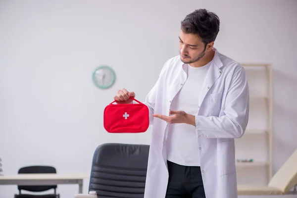 Junger Sanitäter hält Erste-Hilfe-Tasche in der Hand — Stockfoto