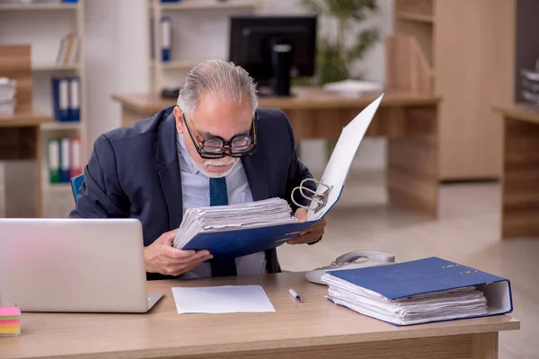 Homem velho empregado auditor vestindo muitos óculos no local de trabalho — Fotografia de Stock