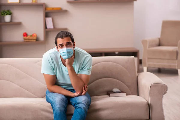 Ung mann sitter hjemme under pandemien – stockfoto