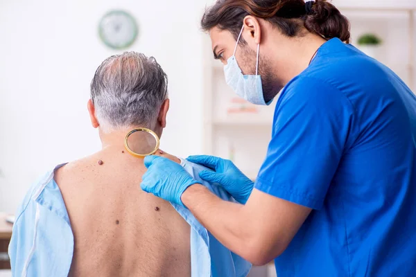 Viejo visitando joven médico dermatólogo — Foto de Stock