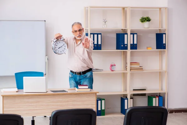시간 관리 개념의 교실에 있는 나이든 남자 교사 — 스톡 사진