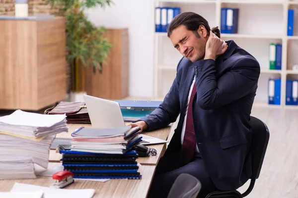 Young male employee unhappy with excessive work — Stock Photo, Image