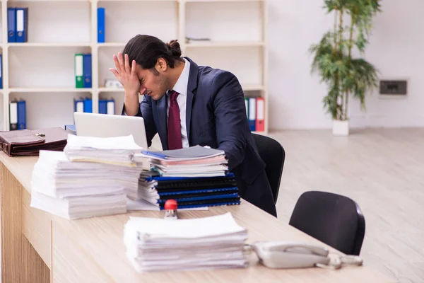 Joven empleado masculino infeliz con el trabajo excesivo — Foto de Stock