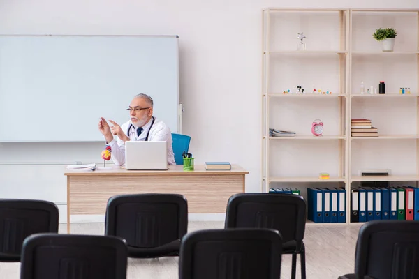 Öreg férfi orvos tanár az osztályteremben a világjárvány idején — Stock Fotó