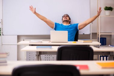 Sınıftaki genç erkek öğrenci.