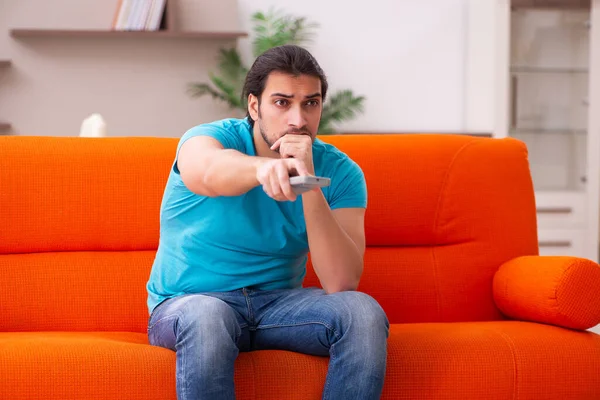 Jovem estudante assistindo tv dentro de casa — Fotografia de Stock