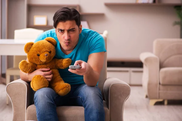 Young man sitting with bear toy at home — Stock Photo, Image