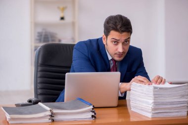 Genç işadamı ve ofiste çok fazla iş var.