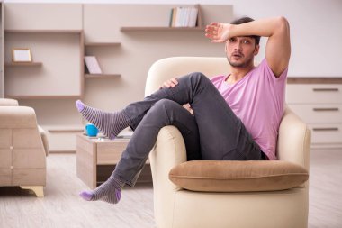 Salgın sırasında evde oturan genç adam.