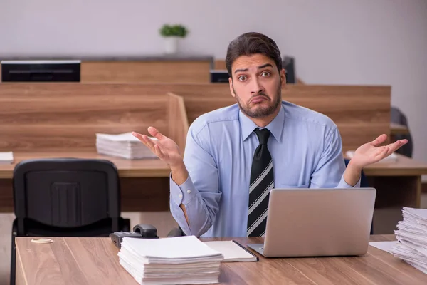 Junge männliche Mitarbeiter und zu viel Arbeit im Büro — Stockfoto