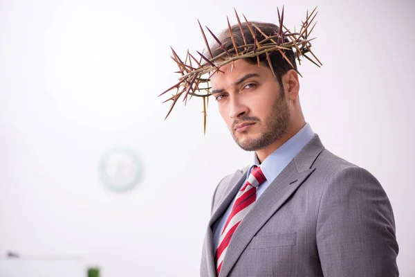 Mladý muž zaměstnanec nosí pichlavý věnec na hlavě — Stock fotografie