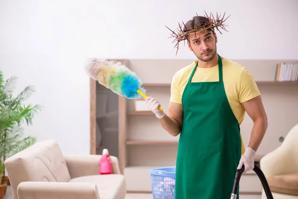 Jonge mannelijke aannemer draagt stekelige krans op het hoofd schoonmaken th — Stockfoto