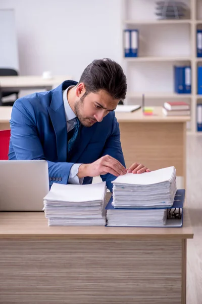 Empleado joven de negocios y demasiado trabajo en la oficina — Foto de Stock