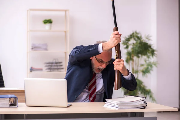 Starý podnikatel zaměstnanec držící riffle v kanceláři — Stock fotografie