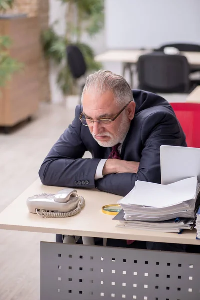 Empleado de edad avanzada y demasiado trabajo en el lugar de trabajo — Foto de Stock