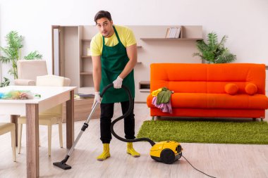 Genç müteahhit evin içini temizliyor.