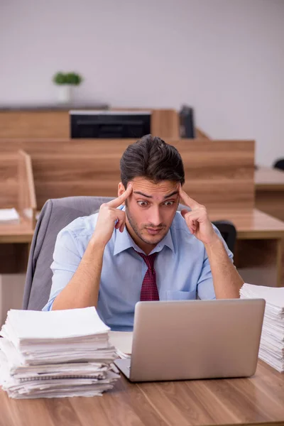 Joven empleado masculino descontento con el trabajo excesivo en la oficina — Foto de Stock