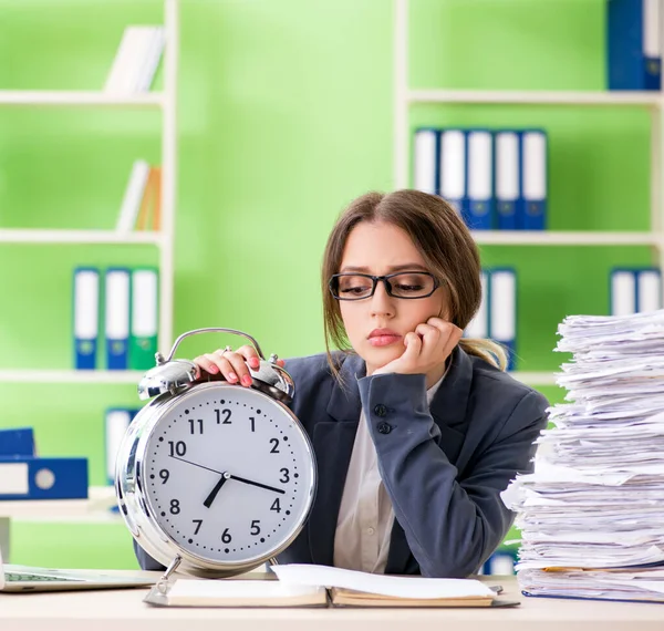 Ung kvinnlig anställd mycket upptagen med löpande pappersarbete i tid m — Stockfoto