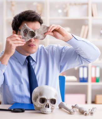 Komik çılgın profesör insan iskeletini inceliyor.