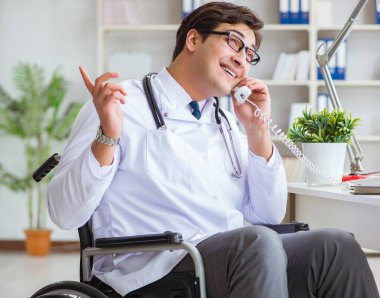 Hastanede çalışan tekerlekli sandalyedeki engelli doktor.