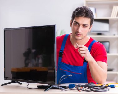 Profesyonel tamir mühendisi bozuk televizyonu tamir ediyor.