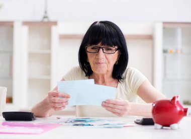 Faturalarını ödemeye çalışan olgun bir kadın.