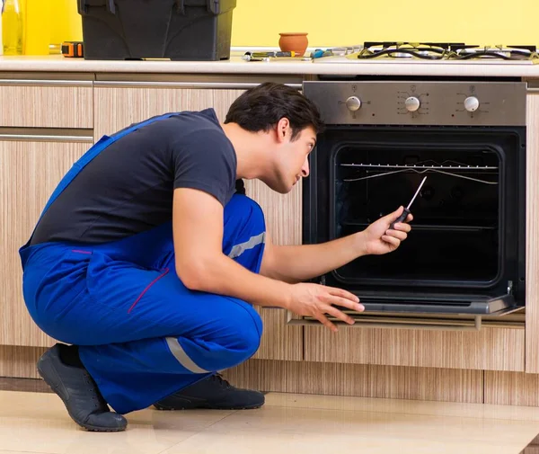 Joven contratista de servicio ensamblando muebles de cocina —  Fotos de Stock