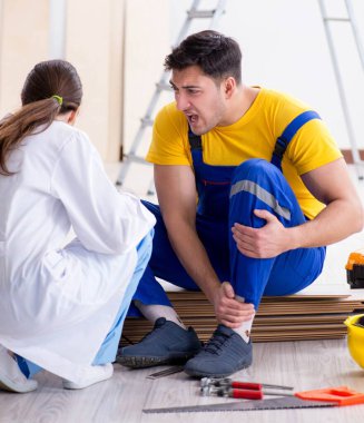 Bacağı ve doktoru yaralı bir işçi.